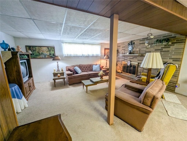 below grade area featuring a fireplace, carpet, and a paneled ceiling
