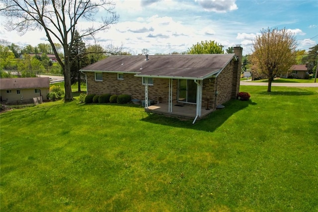 back of house with a chimney and a yard