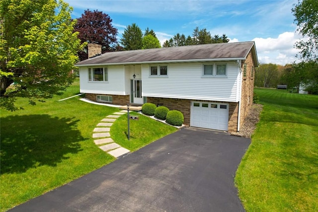 raised ranch featuring a chimney, driveway, a front yard, and a garage