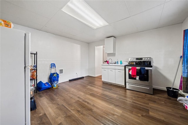 kitchen featuring stainless steel range with electric cooktop, freestanding refrigerator, white cabinetry, and a sink