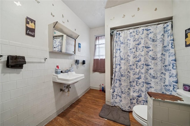 full bathroom with wood finished floors, tile walls, toilet, a sink, and a shower with curtain