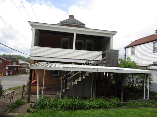 643 Indiana Ave, Glassport, PA 15045 - rear view of house featuring stairway, fence, brick siding, and a chimney