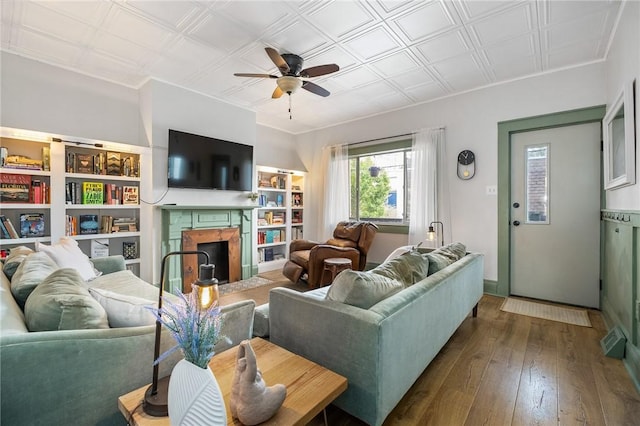 living area featuring a ceiling fan, hardwood / wood-style flooring, and a high end fireplace