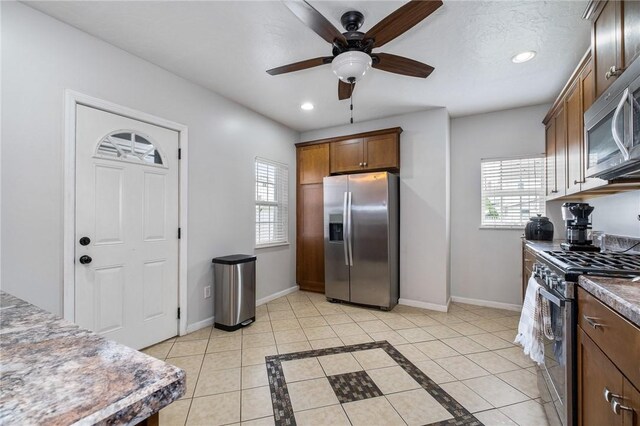 kitchen with appliances with stainless steel finishes, plenty of natural light, baseboards, a ceiling fan, and recessed lighting