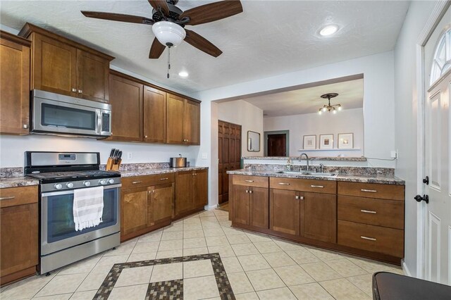 kitchen with appliances with stainless steel finishes, a sink, recessed lighting, light tile patterned floors, and ceiling fan