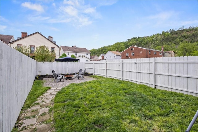 view of yard with an outdoor fire pit and a residential view