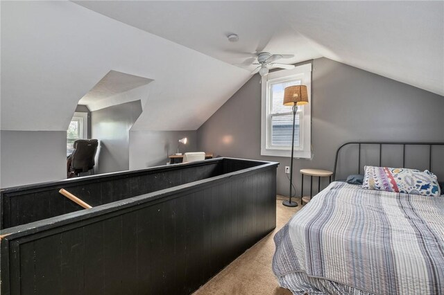 bedroom featuring light colored carpet, vaulted ceiling, and an office area