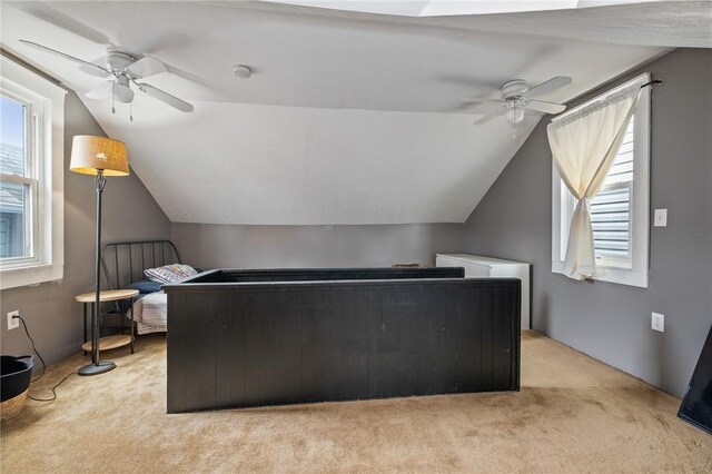 additional living space featuring a ceiling fan, light colored carpet, and lofted ceiling