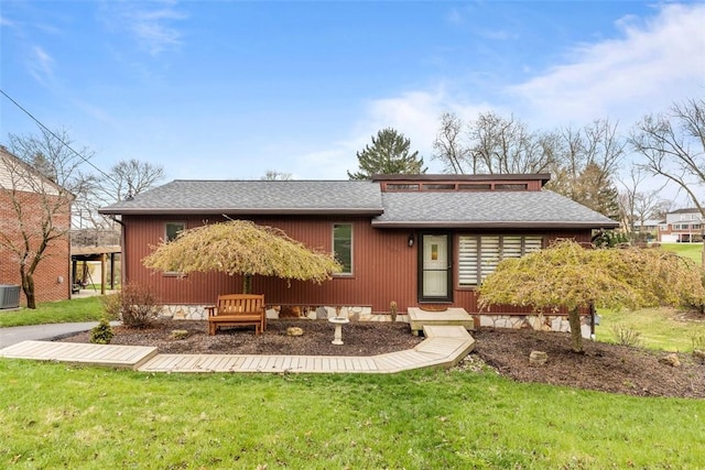 back of property featuring a shingled roof, a yard, and central AC unit
