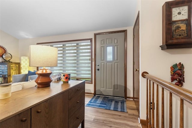 foyer entrance with light wood finished floors and baseboards