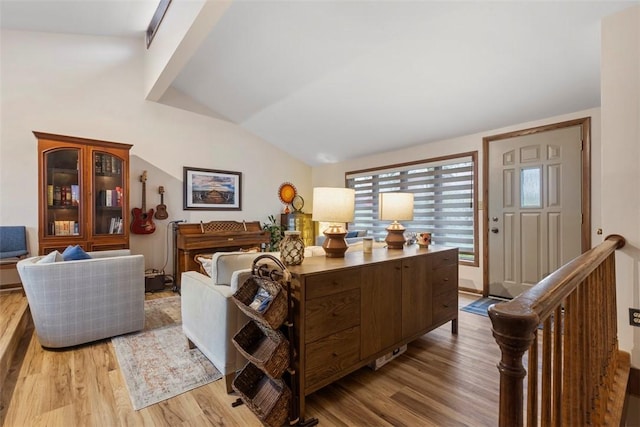 living room with wood finished floors, vaulted ceiling, and healthy amount of natural light