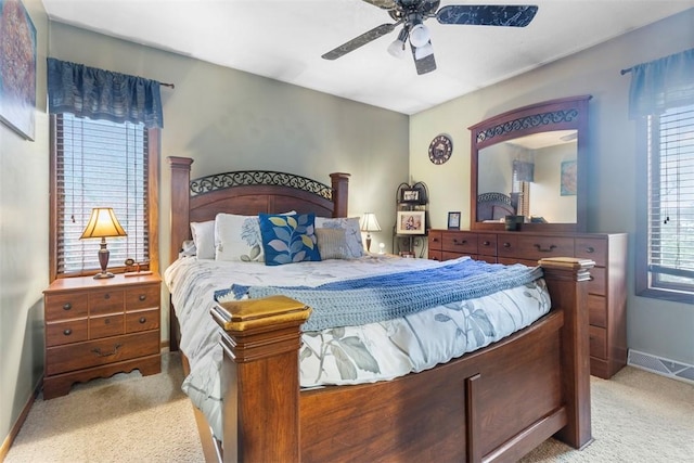 bedroom with light colored carpet, baseboards, and a ceiling fan