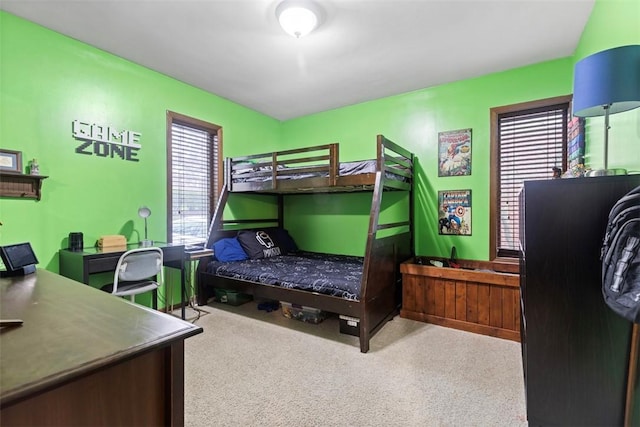 bedroom featuring multiple windows, carpet floors, and an office area