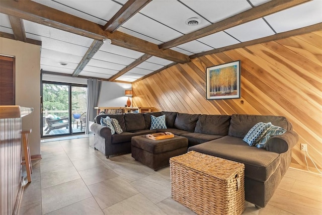 living area featuring beam ceiling and wooden walls