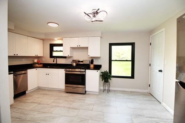 513 Crestview Dr, Plum Boro, PA 15239 - kitchen featuring stainless steel appliances, plenty of natural light, light marble finish floors, and dark countertops