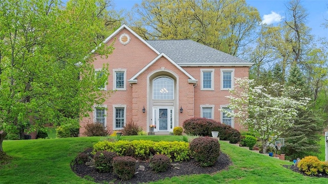 view of front of property featuring a front lawn and brick siding