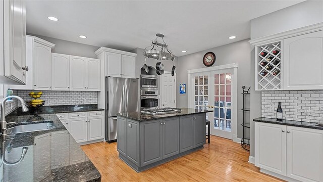 kitchen with stainless steel appliances, a sink, white cabinets, and recessed lighting