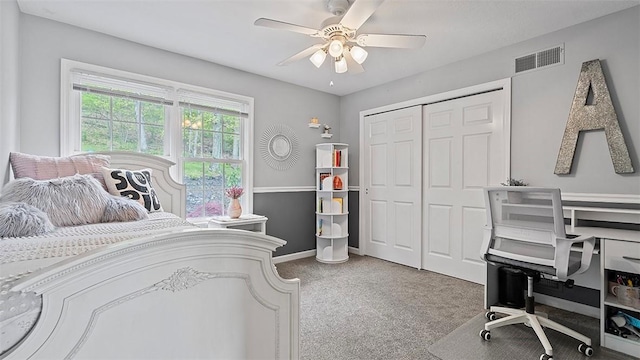 carpeted bedroom with a ceiling fan, a closet, and baseboards