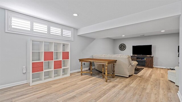 living area with wood finished floors, baseboards, recessed lighting, and healthy amount of natural light