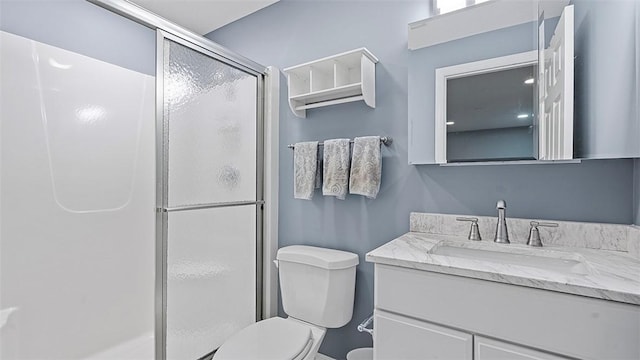 full bathroom with a shower stall, toilet, and vanity
