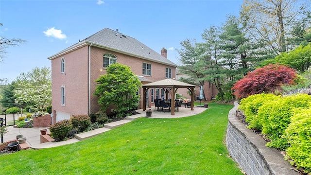 back of house featuring a gazebo, a yard, a garage, a chimney, and a patio area