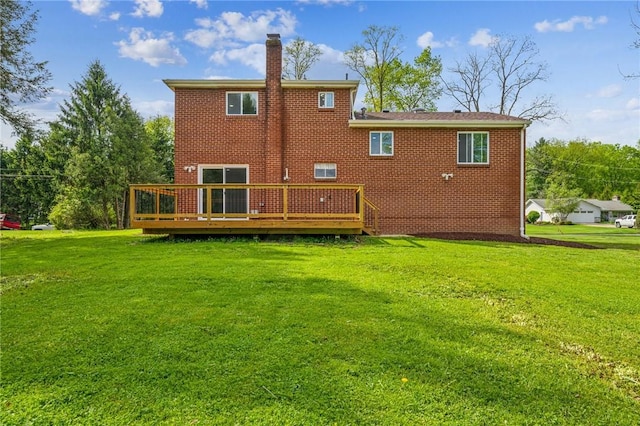 back of house with a chimney, a yard, a wooden deck, and brick siding