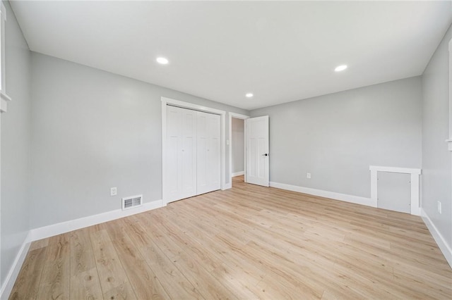 unfurnished bedroom featuring light wood finished floors, a closet, baseboards, and recessed lighting