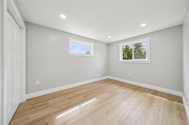 unfurnished bedroom with baseboards, wood finished floors, a closet, and recessed lighting