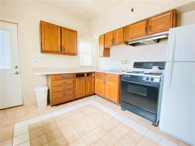811 Farragut St, Highland Park, PA 15206 - kitchen with black gas range, freestanding refrigerator, under cabinet range hood, light countertops, and brown cabinetry