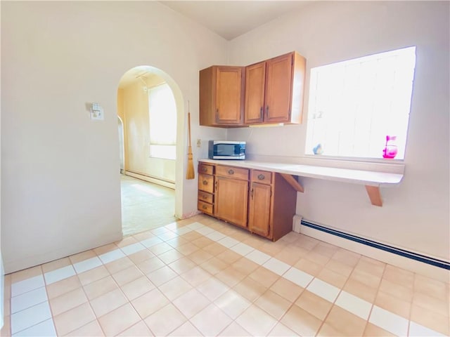 811 Farragut St, Highland Park, PA 15206 - kitchen with stainless steel microwave, brown cabinetry, baseboard heating, and light countertops