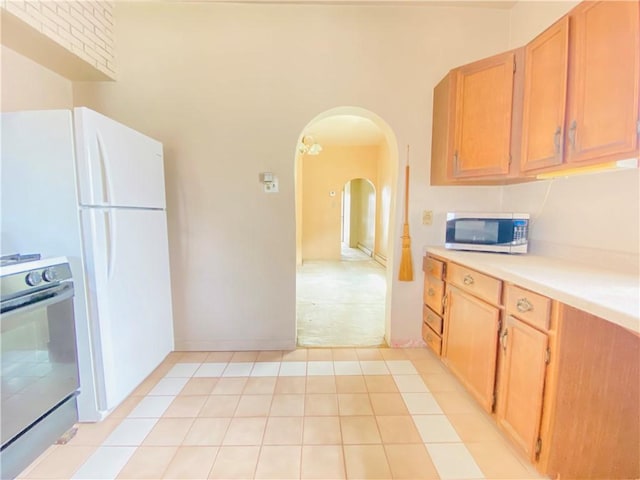 811 Farragut St, Highland Park, PA 15206 - kitchen with stainless steel microwave, stove, arched walkways, light countertops, and light tile patterned floors