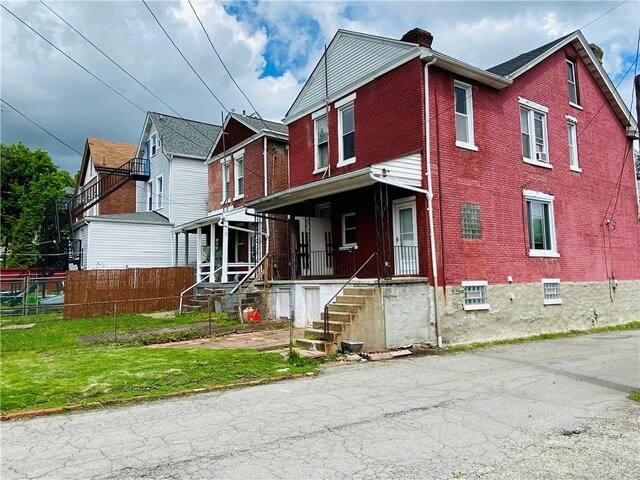 811 Farragut St, Highland Park, PA 15206 - multi unit property featuring brick siding, a chimney, fence, and covered porch