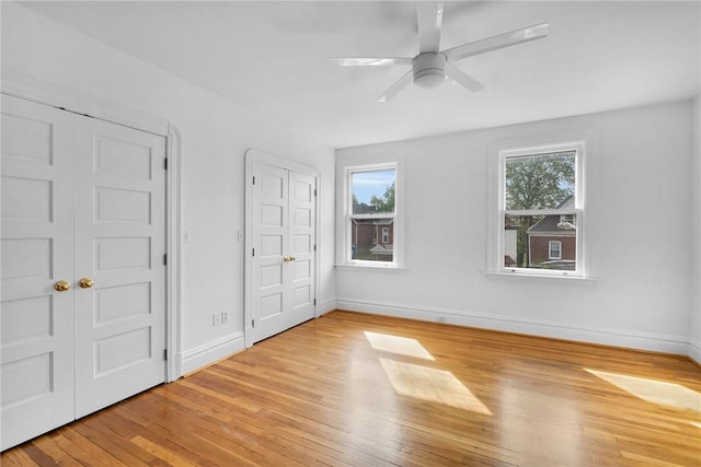 unfurnished bedroom featuring light wood-style floors, baseboards, and ceiling fan