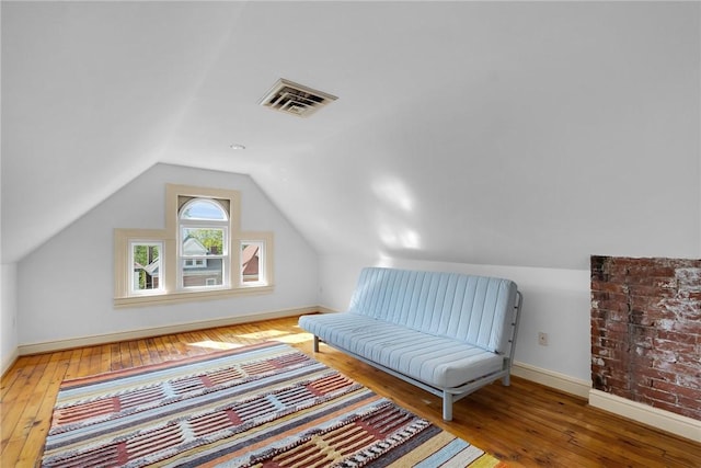 living area with wood-type flooring, baseboards, and lofted ceiling