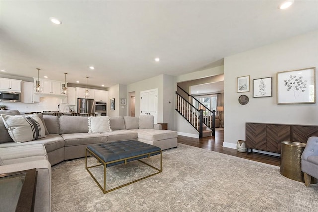 living area featuring wood finished floors, stairway, recessed lighting, and baseboards