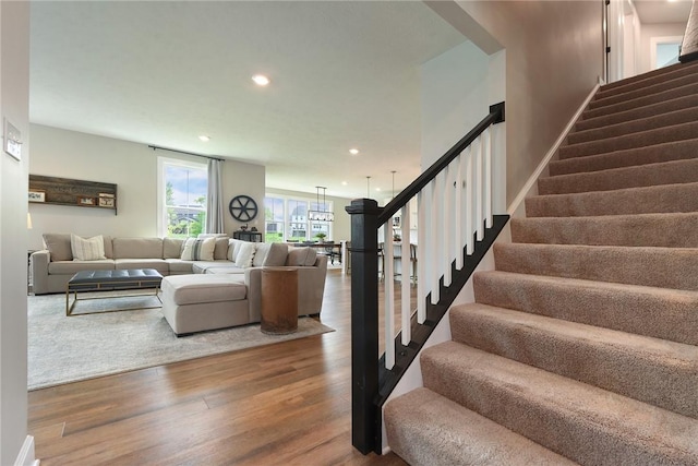 staircase with wood finished floors and recessed lighting
