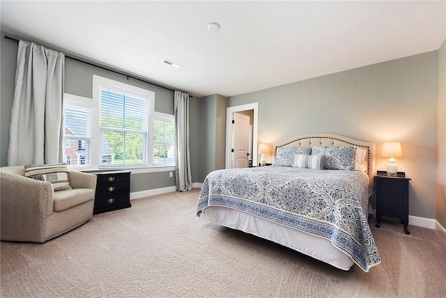 bedroom featuring light colored carpet and baseboards