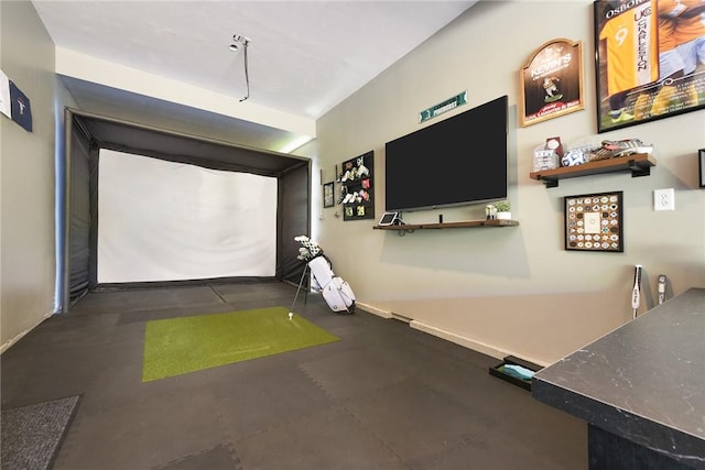 playroom with golf simulator, baseboards, and rubber floors