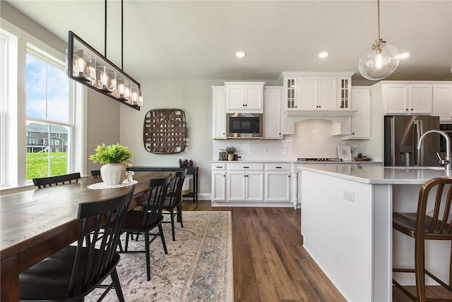 kitchen featuring appliances with stainless steel finishes, dark wood-style flooring, decorative backsplash, white cabinets, and recessed lighting