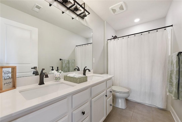 bathroom with tile patterned floors, toilet, and double vanity