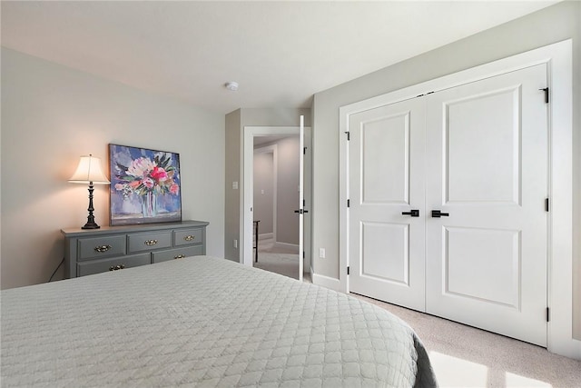carpeted bedroom featuring a closet and baseboards