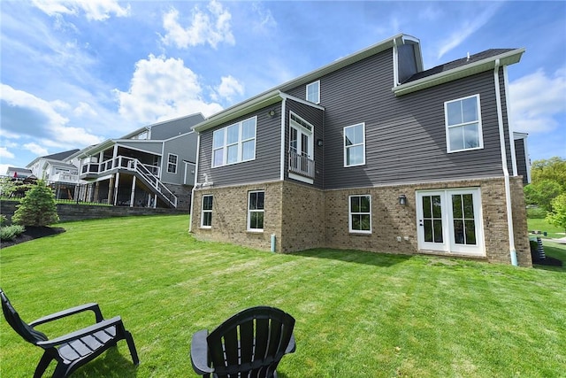 rear view of property with a lawn and brick siding