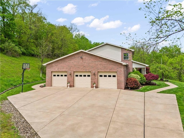 view of front of home with brick siding, concrete driveway, a front lawn, and a garage