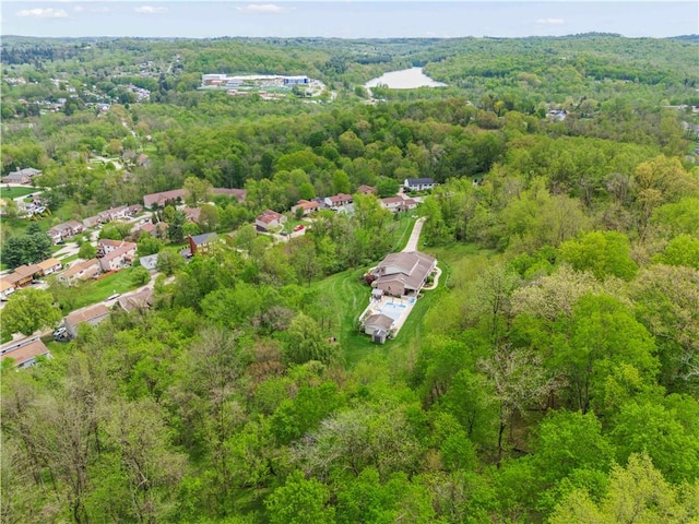 aerial view of property and surrounding area featuring a heavily wooded area