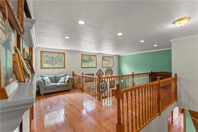 interior space featuring an upstairs landing, hardwood / wood-style flooring, crown molding, recessed lighting, and a textured ceiling