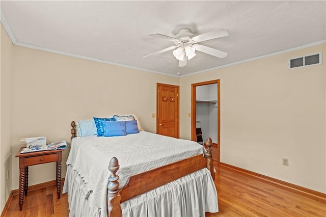 bedroom featuring light wood-style flooring, ornamental molding, baseboards, and a ceiling fan