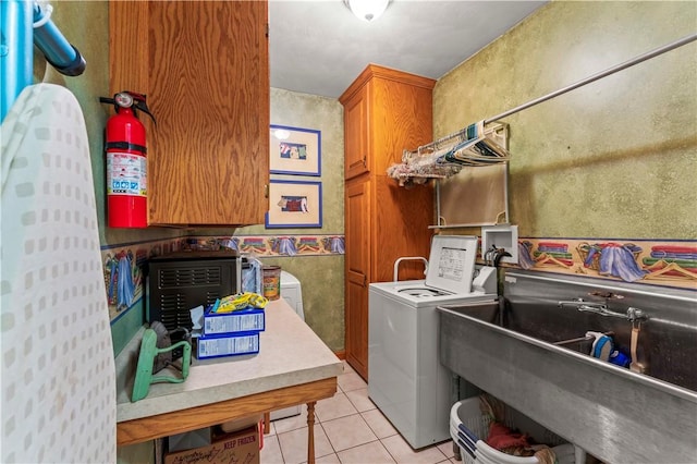 laundry room featuring washer and dryer, light tile patterned floors, and cabinet space