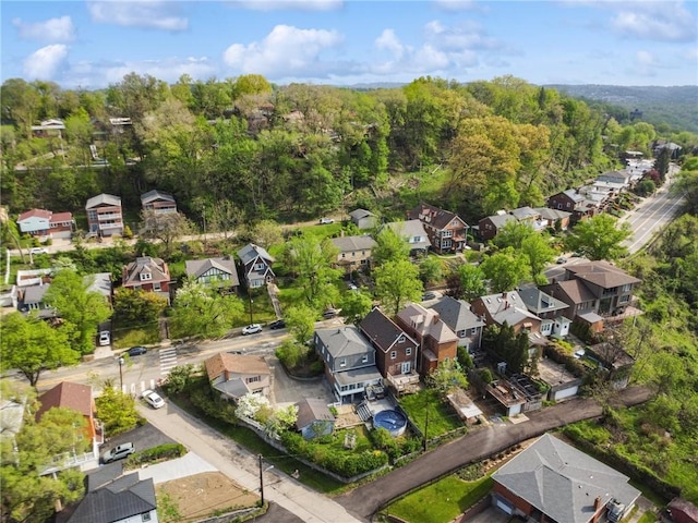 aerial overview of property's location with nearby suburban area and a heavily wooded area
