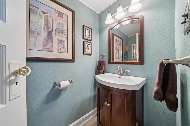 bathroom featuring vanity, baseboards, and a chandelier