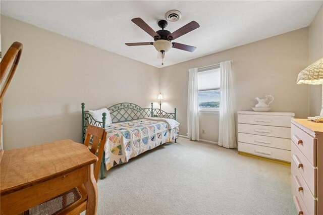 bedroom with light colored carpet, a ceiling fan, and baseboards